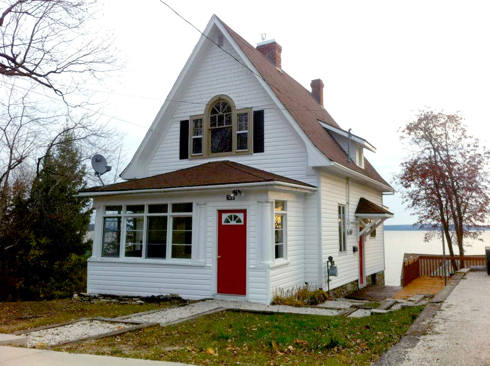 Front view of the Guest House located at 655 Brewster Street in Haileybury (Temiskaming Shores). The house is part of the Presidents’ Suites historical homes. With great views on lake Temiskaming, it was built in 1927 by Jim McRae, editor of the Northern Miner. / Vue avant de la Maison d’hôtes située au 655 rue Brewster à Haileybury. La maison fait partie des maisons historiques des Suites des Présidents. Avec de magnifiques vues sur le lac Timiskaming, elle a été construite en 1927 par Jim McRae, editeur du Northern Miner.