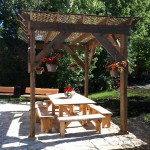 Large backyard with pergola, patio set, benches, fire pit at the Prospector's House in Haileybury / Cours arrière de la Maison des prospecteurs avec pergola, ensemble de patio, et feu de camp.