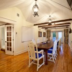 Meeting room of the Lumber Barons' house with can accommodate up to 25 people sitting. The room can be converted to a sleeping area with 5 beds by removing the tables. / Salle de rencontre de la Maison des barons forestiers pouvant accueillir jusqu'à 25 personnes. La salle peut devenir un dortoir avec 5 lits en enlevant les tables.