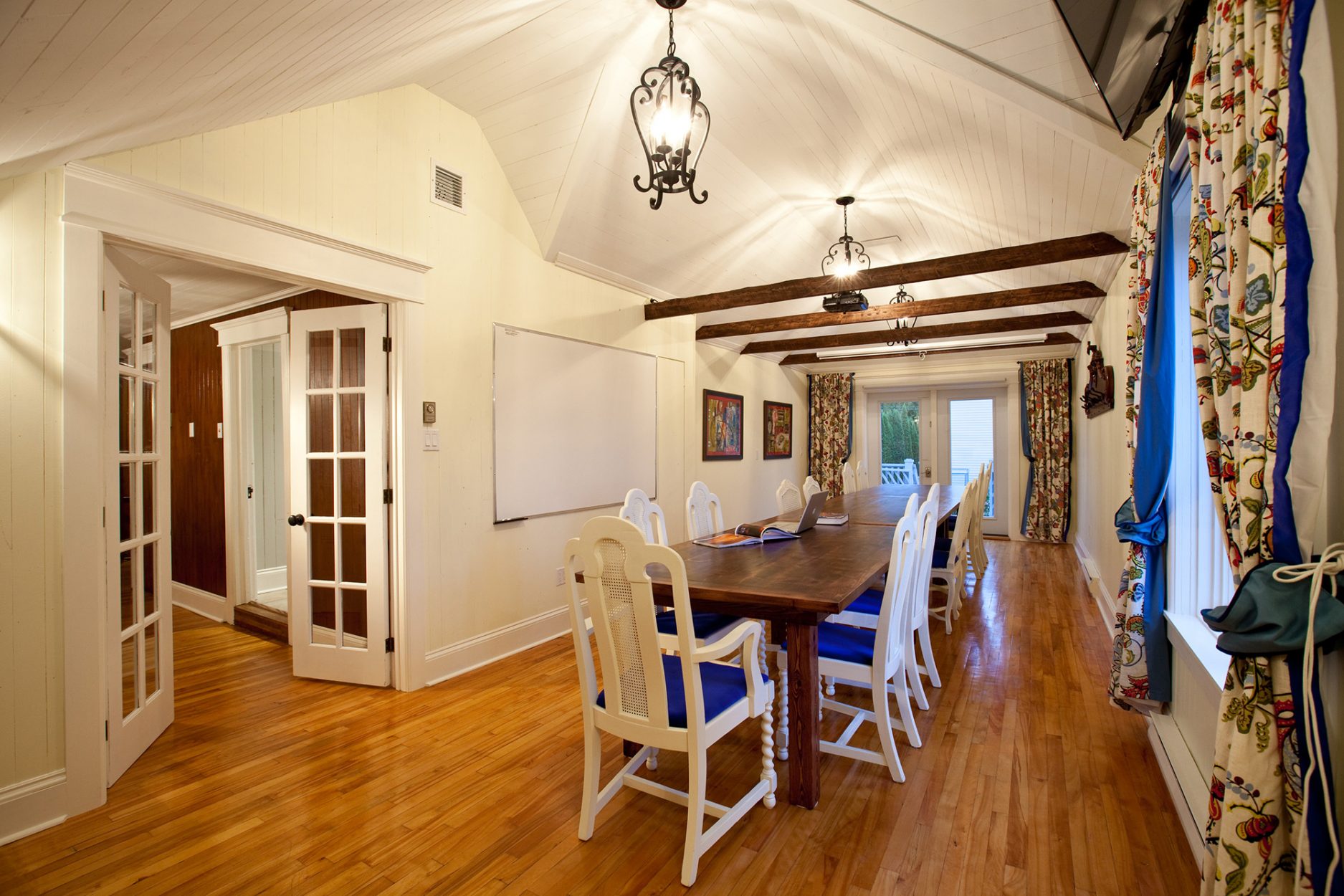 Meeting room of the Lumber Barons' house with can accommodate up to 25 people sitting. The room can be converted to a sleeping area with 5 beds by removing the tables. / Salle de rencontre de la Maison des barons forestiers pouvant accueillir jusqu'à 25 personnes. La salle peut devenir un dortoir avec 5 lits en enlevant les tables.