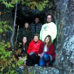 Group standing in front of one of the five mining tunnels at the base of Devil's Rock. The tunnels were blasted out during the Cobalt's silver rush era. / Groupe devant un des tunnels miniers à la base du rocher du diable. Ces tunnels furent creusés lors de la ruée de l'argent de Cobalt.