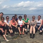 A group on top of Devil's Rock with a spectacular background view of lake Temiskaming. Perfect outing during your stay at the Presidents' Suites in Haileybury. / Un groupe au rocher du diable avec une vue spectaculaire du lac Témiskaming. Expédition parfaite pendant votre séjour aux Suites des Présidents à Temiskaming Shores.