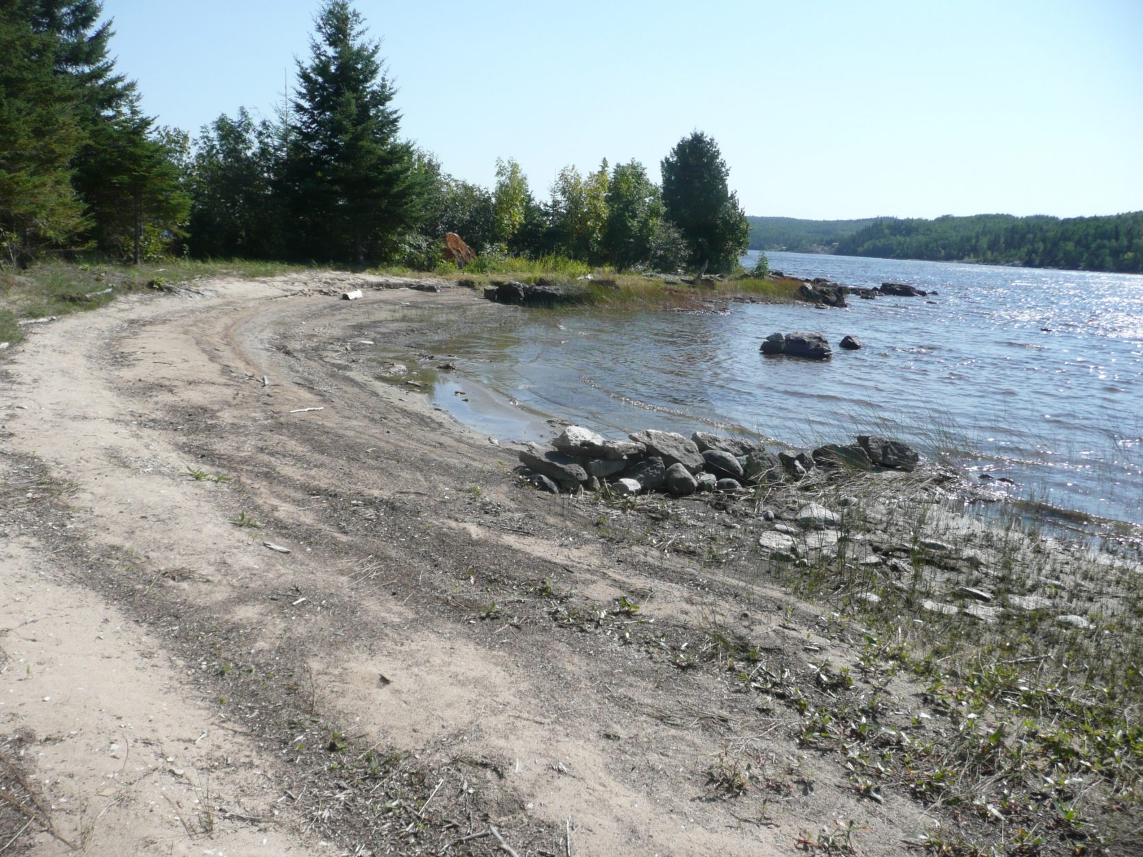 Farr Island beach on west side of the island. This is a unique feature for lake Temiskaming as the rough waters often prevent the formation of a beach. The beach is located on the west side and it does not get affected by the strong north-east winds. / LA plage de l'île Farr sur le côté ouest. La présence d'une plage est assez rare sur le lac Témiskaming à cause des fort vents.