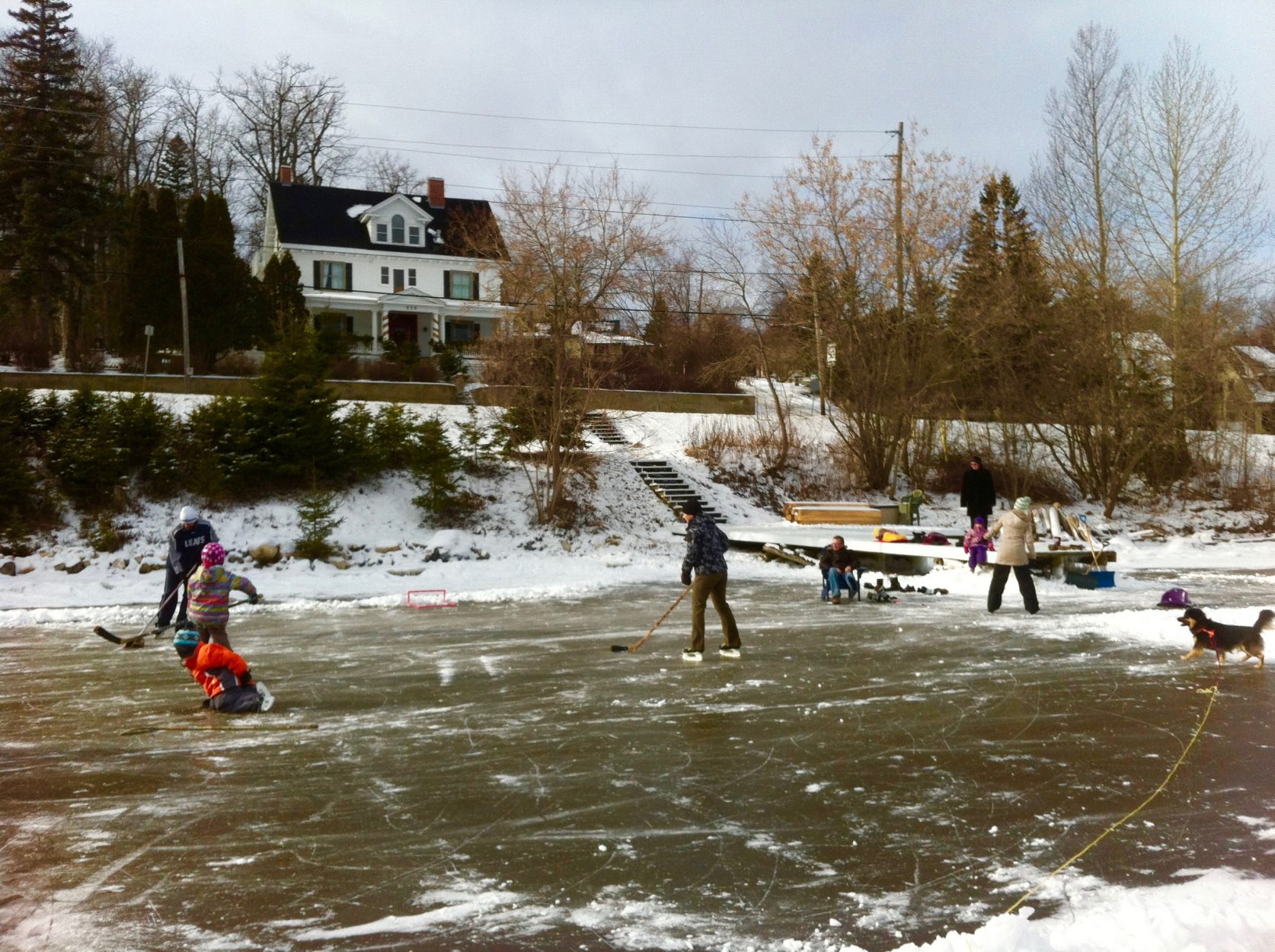Une famille qui s'amuse sur la patinoire en face de la Villa des Suites des Présidents