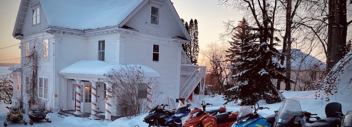 snowmobile group at the Villa of the Presidents Suites in front of lake Temiskaming